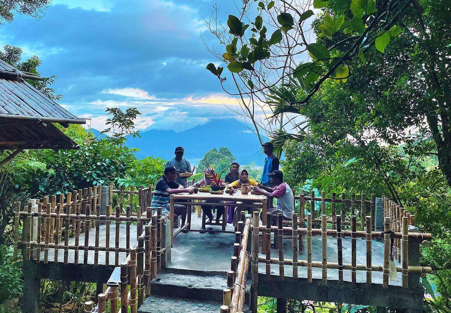 people sitting at table on bamboo balcony of spice village restaurant