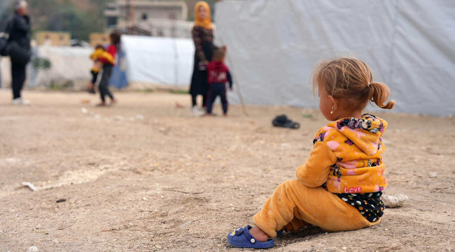 young child sits on ground in Gaza