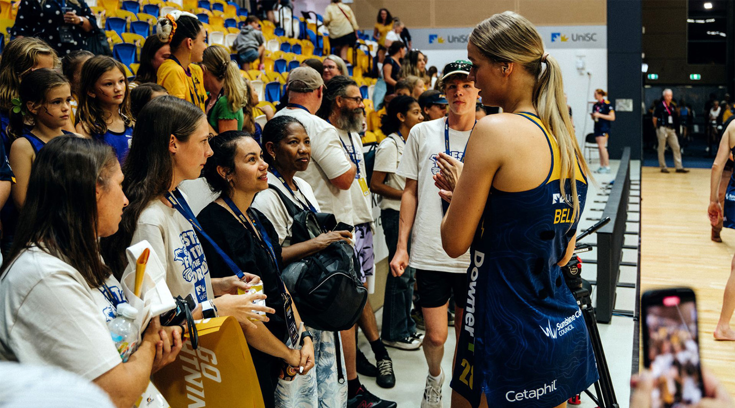 Students chat to Charlie Bell at Lightning netball home game